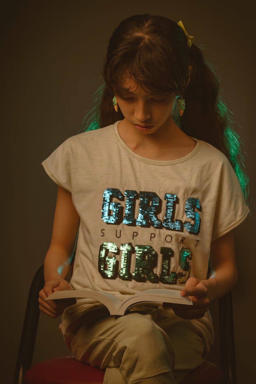 a teenager girl reading a book